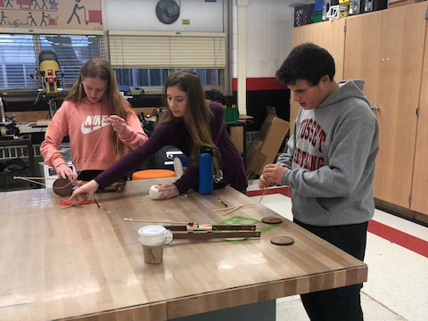Three students working on a technology project